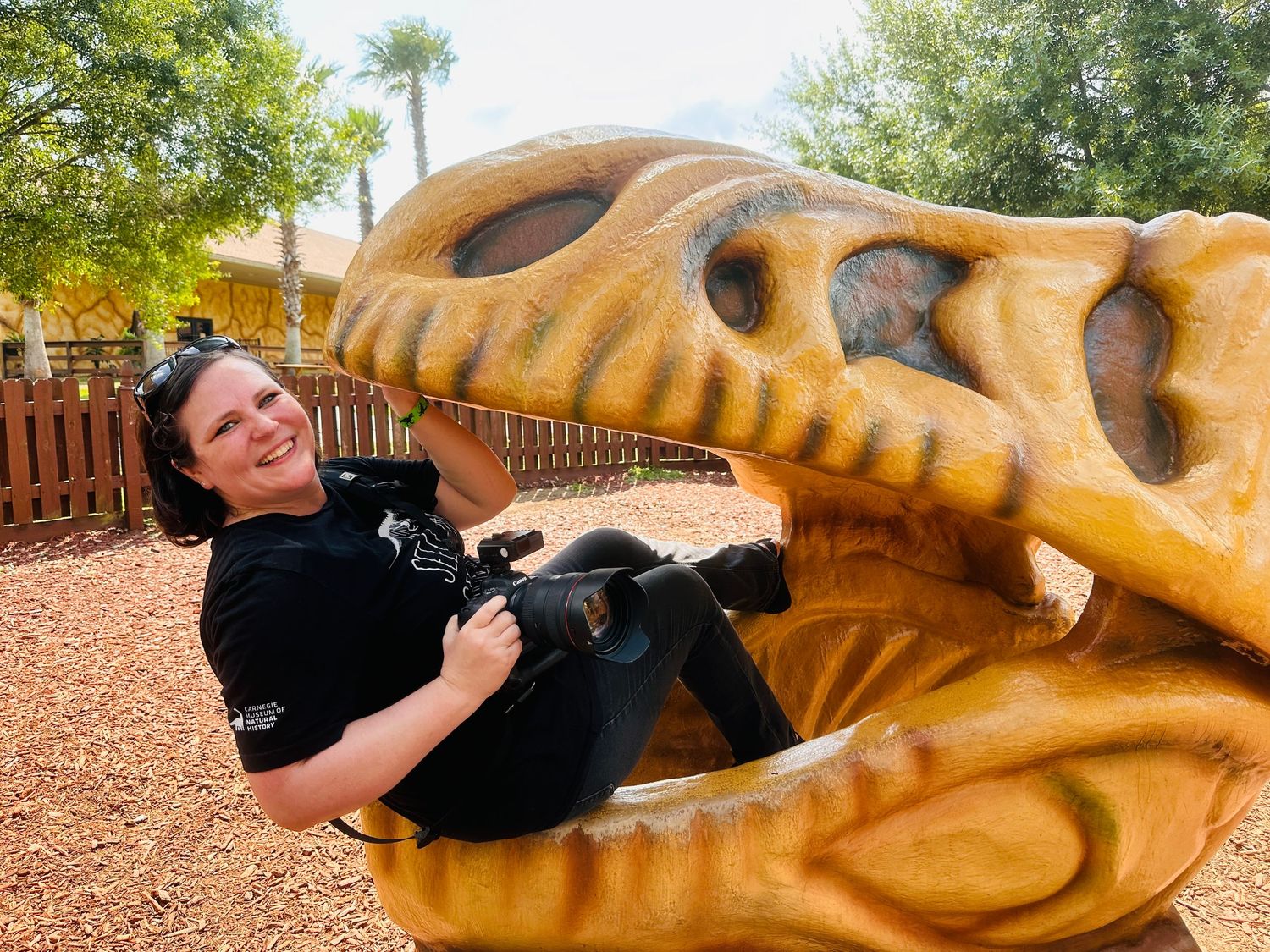IMG 2872 1b0ee0ef 1500 - Receipts and retouching: why every wedding photographer needs a public AI policy Florida wedding photographer Daniella Koontz poses with a camera inside a large plastic dinosaur head. Daniella has a clear wedding photographer AI policy published on her website.