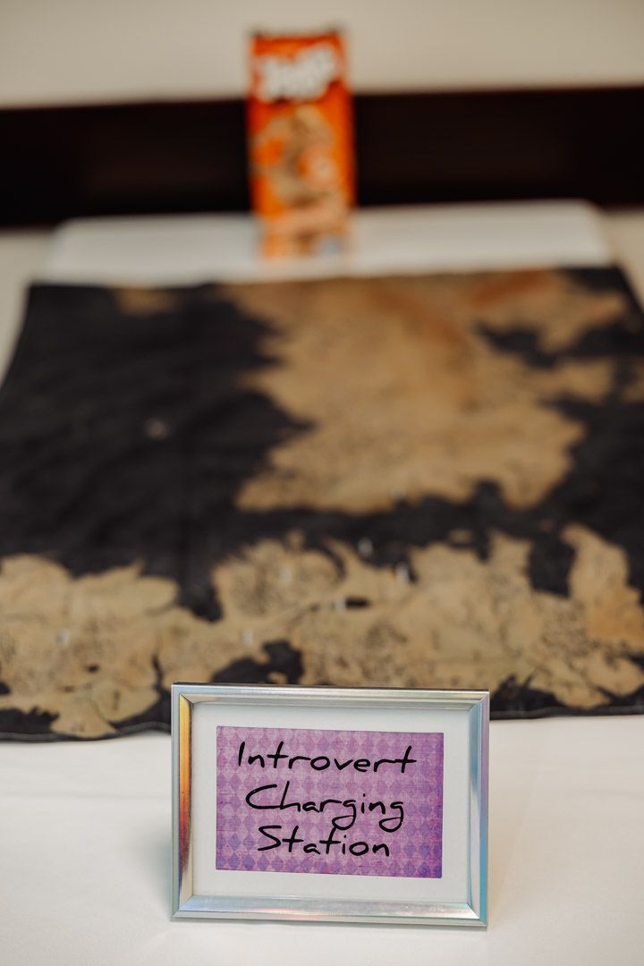 Framed 'Introvert Charging Station' sign with vintage map in background.