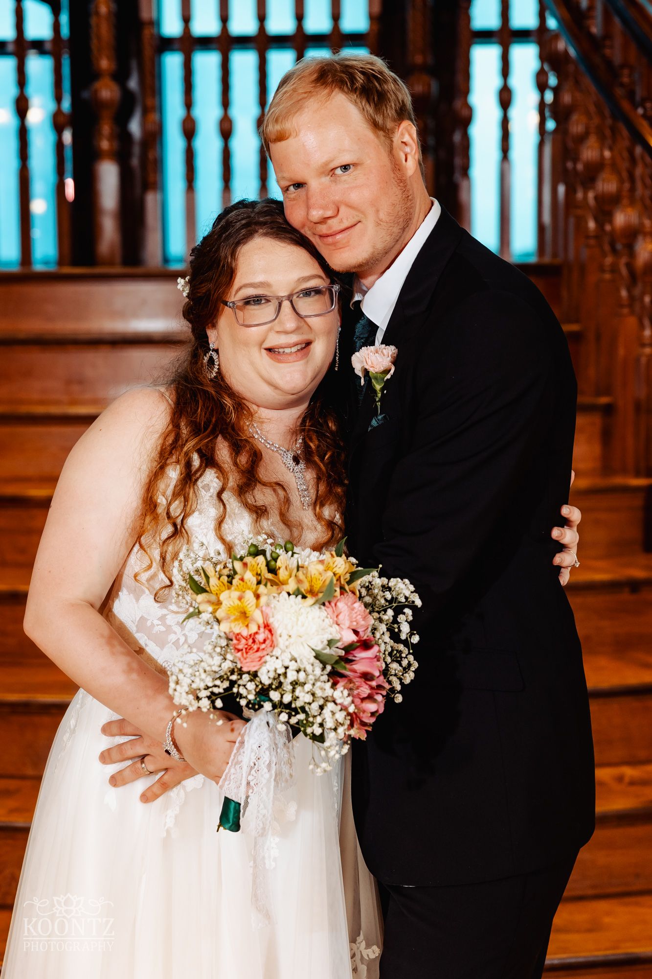 Wedding couple poses together in ornate church interior with warm lighting.