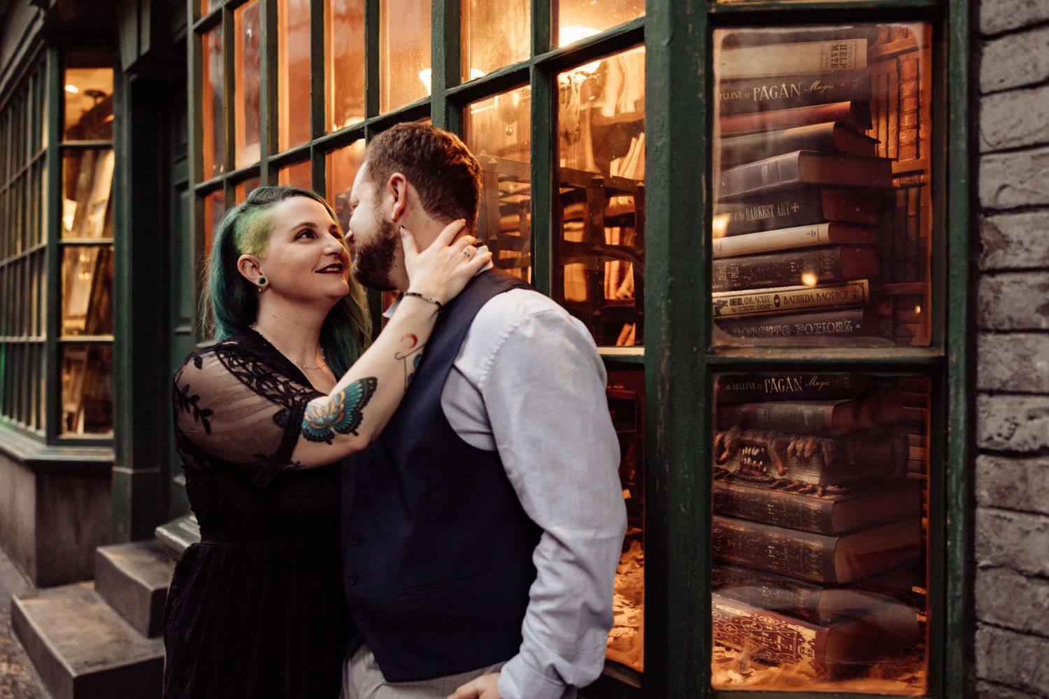 A romantic moment captured against illuminated shop windows in an old city setting.