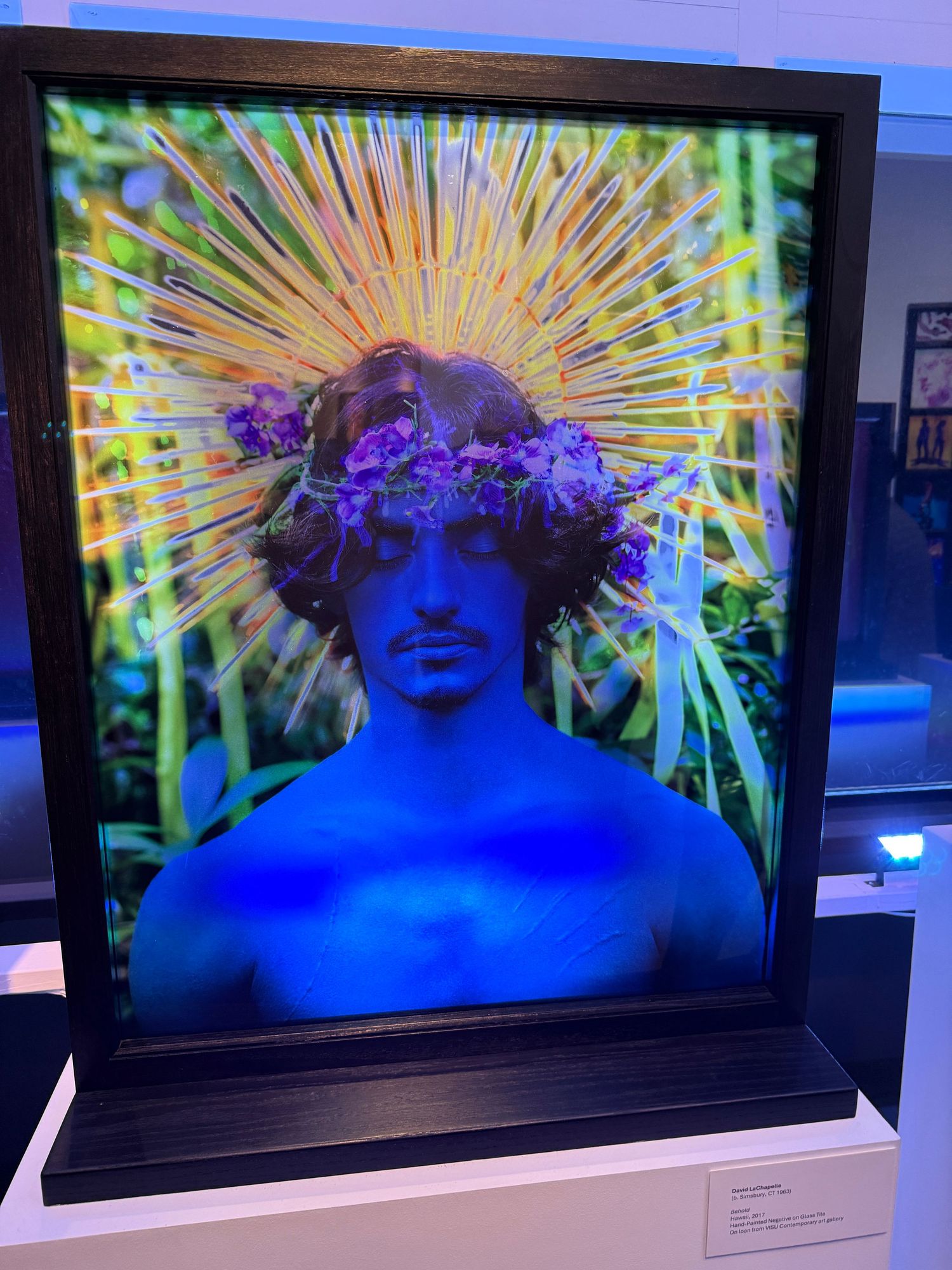 Artistic video installation shows multiple screens displaying vibrant yellow sunburst patterns against blue backgrounds.