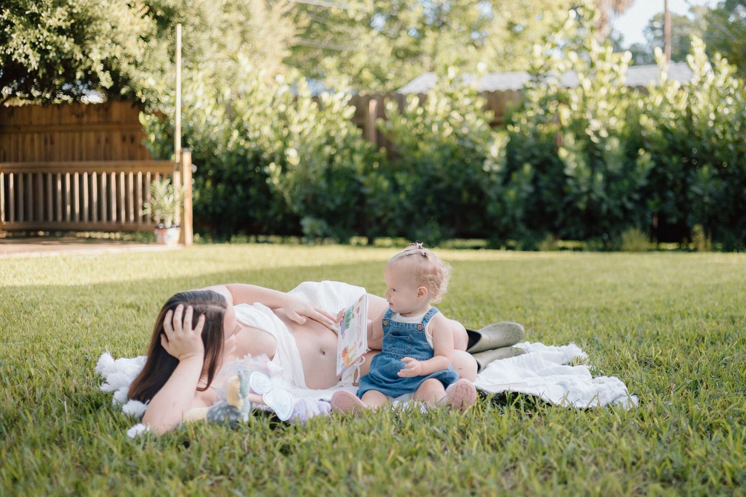 at home maternity session, playful backyard session in st. petersburg florida. documentary style photos shoot featuring backyard hose play.