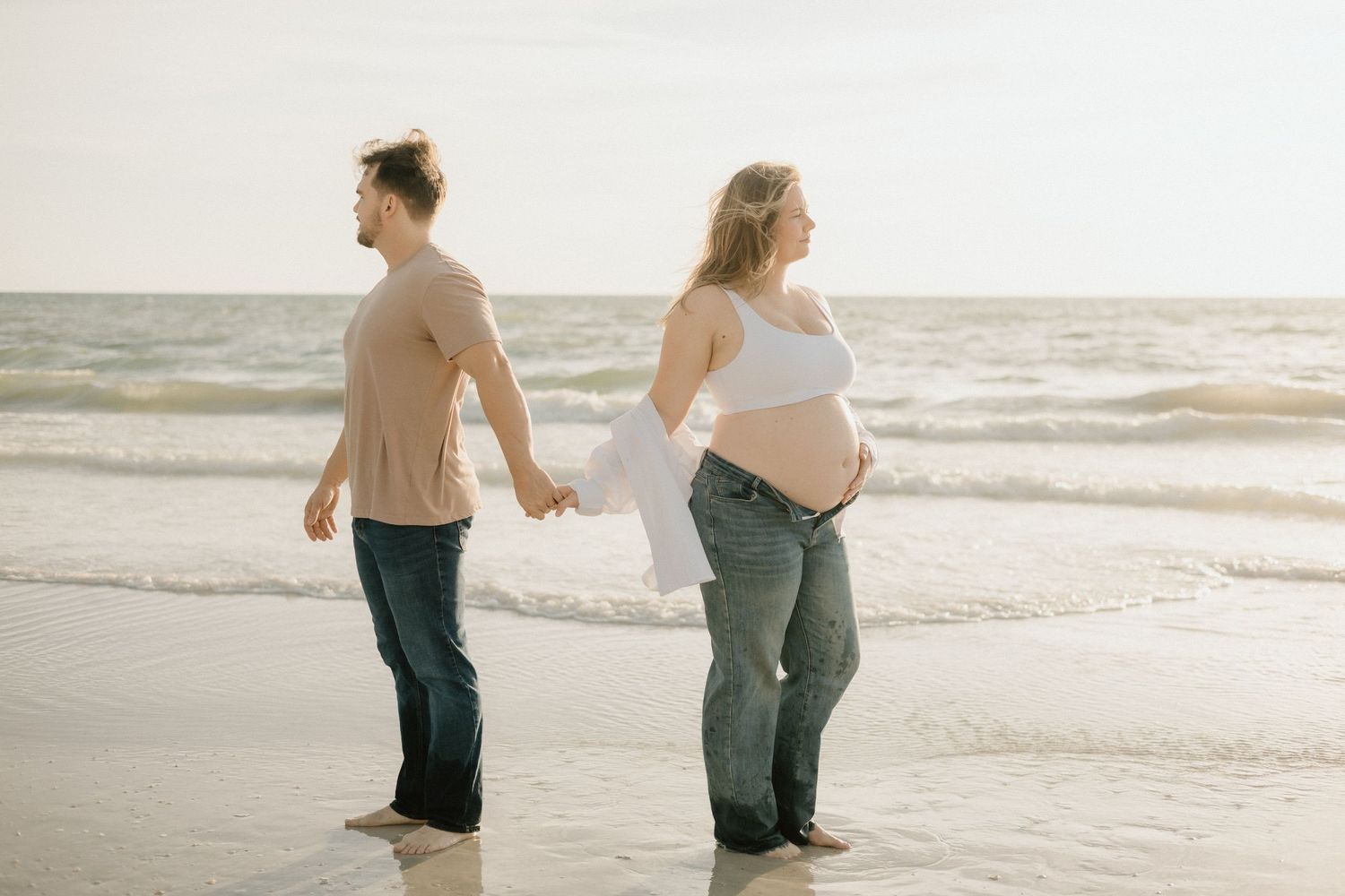 Mother-to-be walking along the beach during a relaxed St. Pete maternity session.