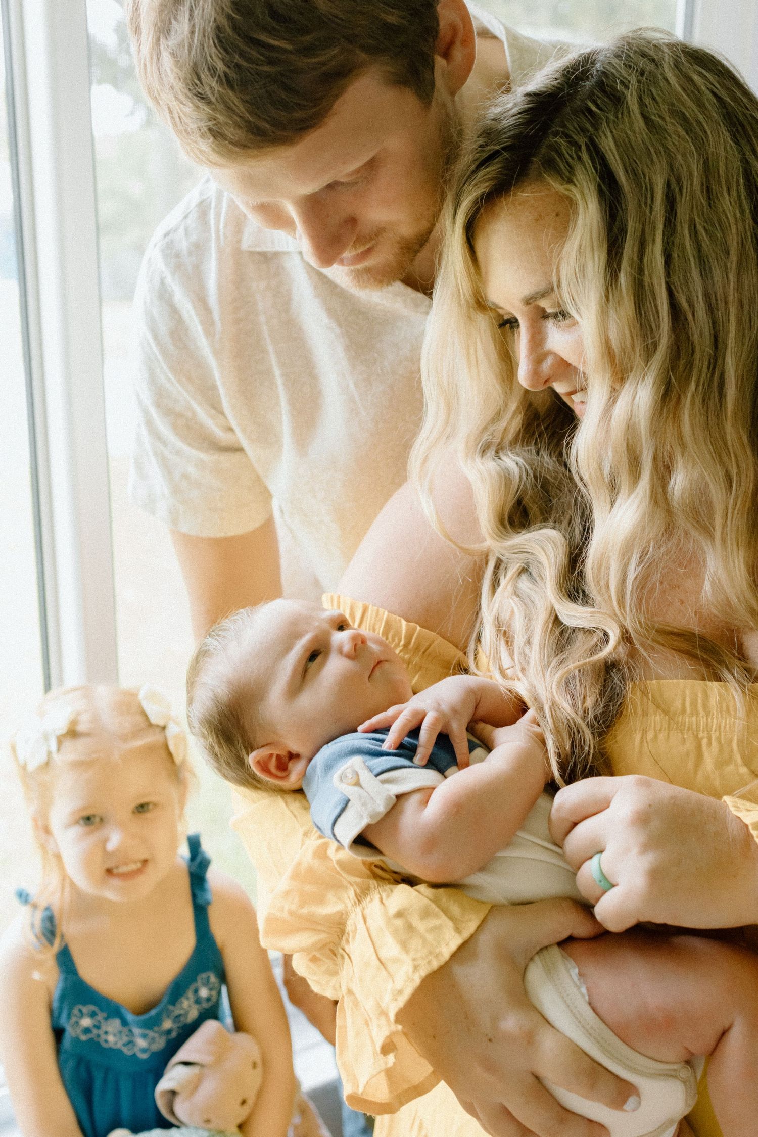 Parents cuddling their children during a natural family photography session.  in home session st. petersburg clearwater