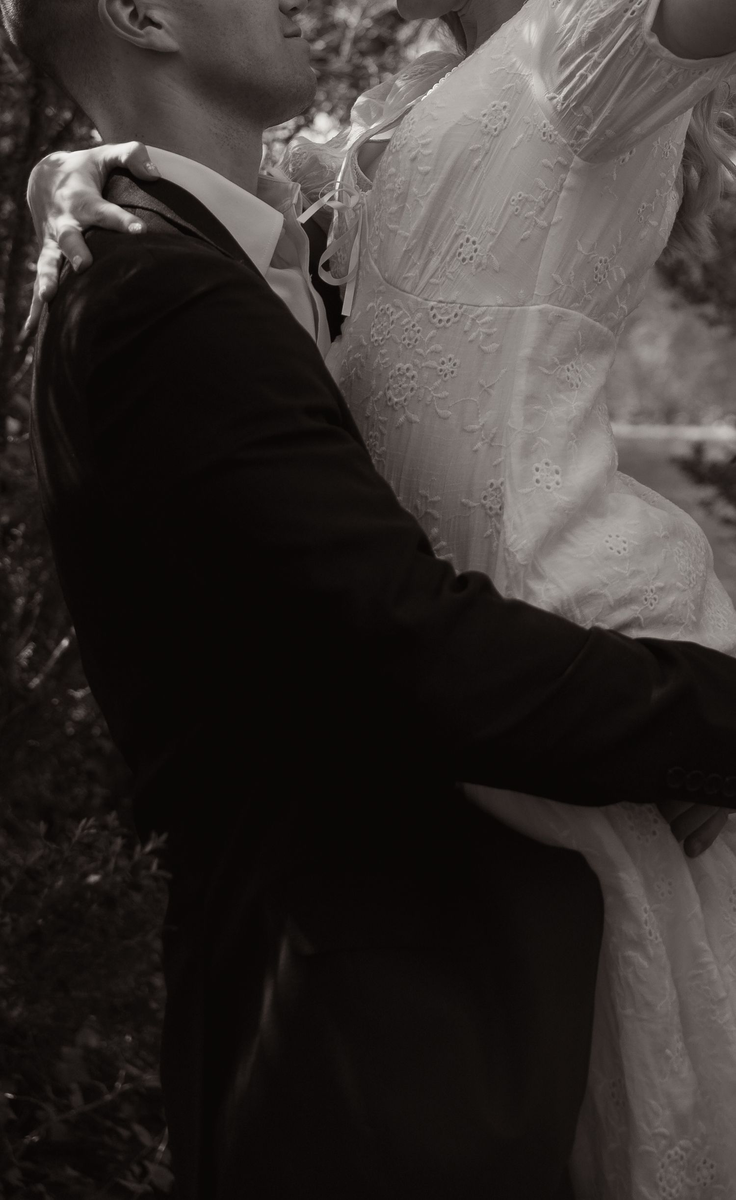Black and white romantic photo of bride and groom embracing in an elegant wedding portrait. Taken by Row And Co Photography in FXBG VA