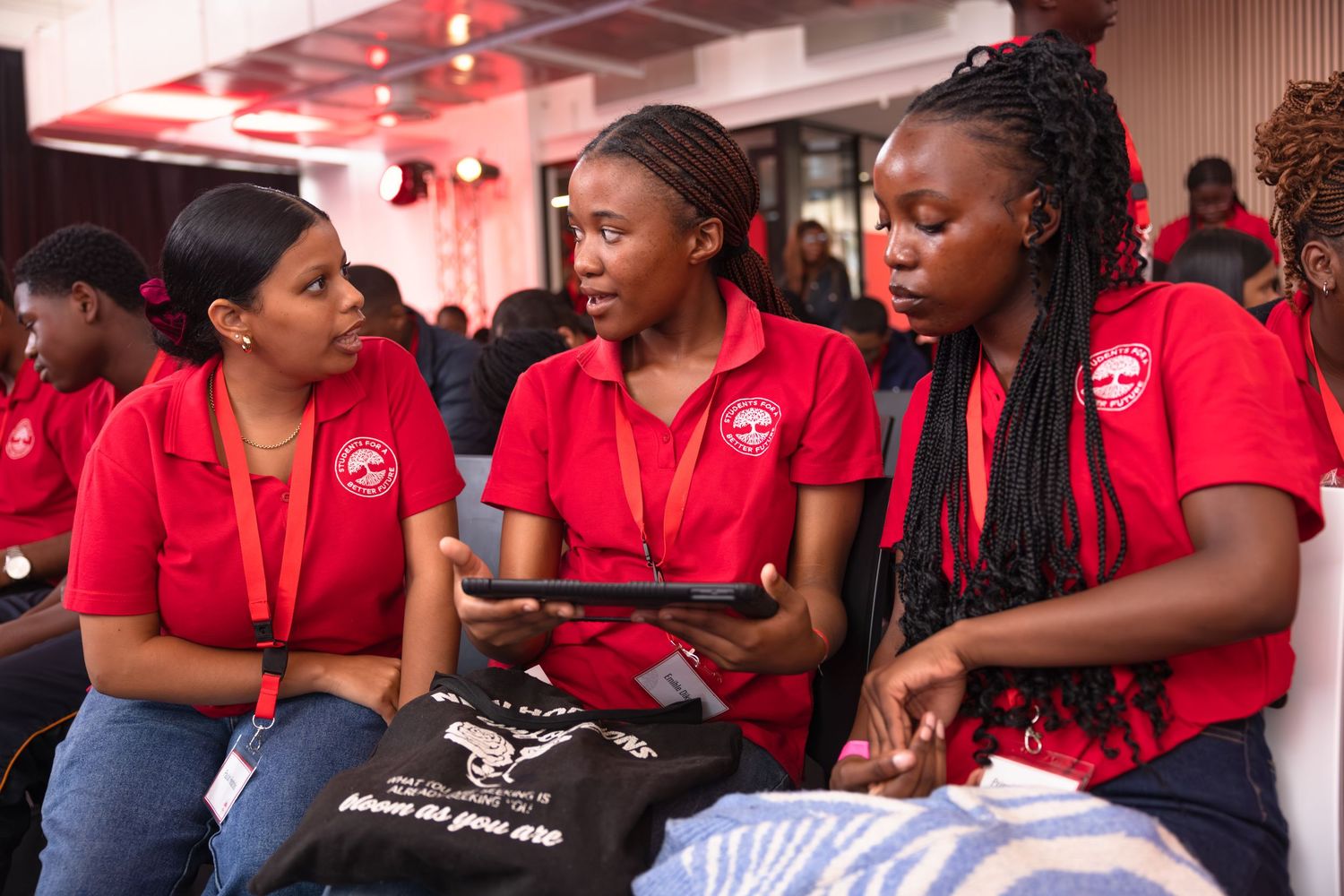 Group wearing matching red shirts gathered at professional conference event.