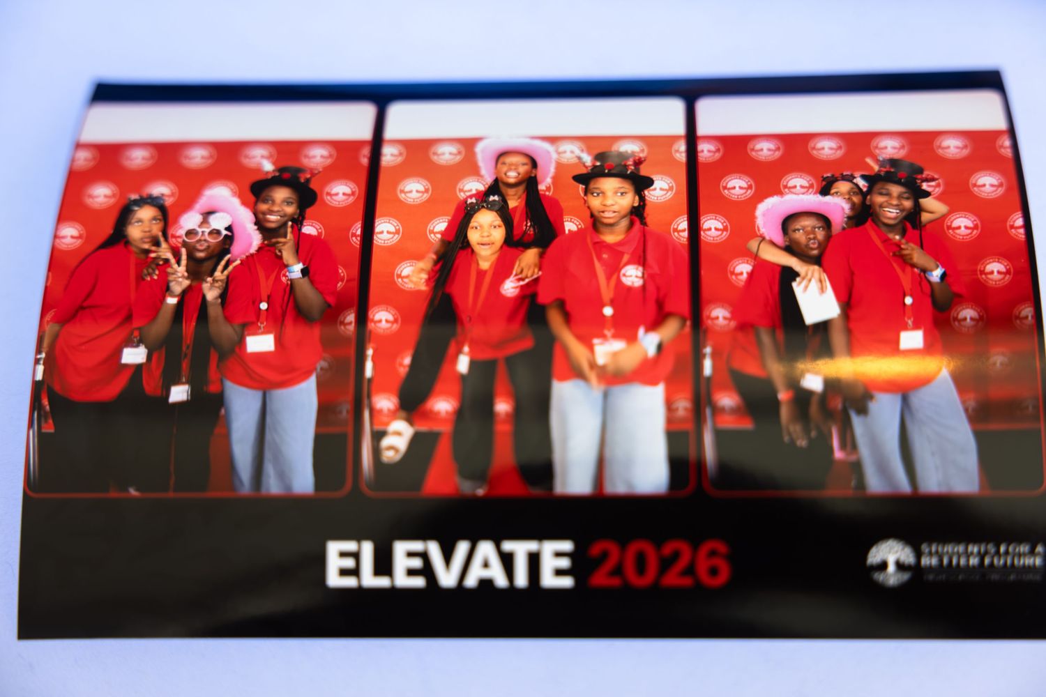 Large group of attendees in red shirts gathered at a conference event with 'ELEVATE 2026' signage visible.