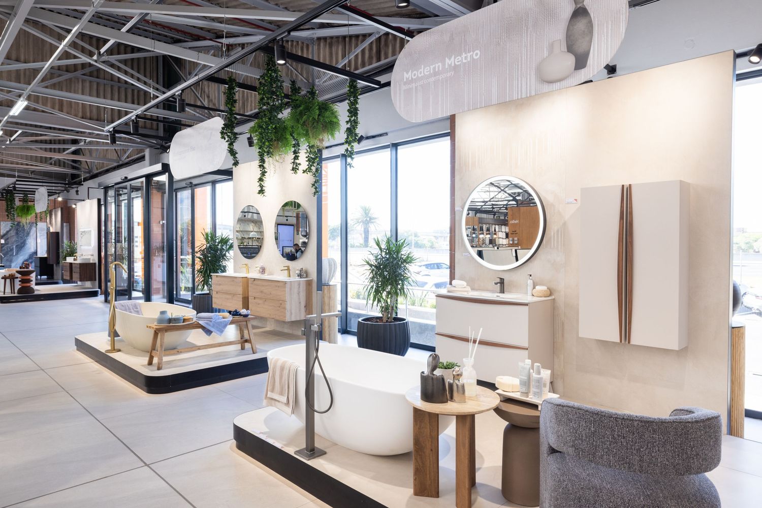 Bright modern office space with white walls, exposed ceiling, and potted plants creating a clean aesthetic.