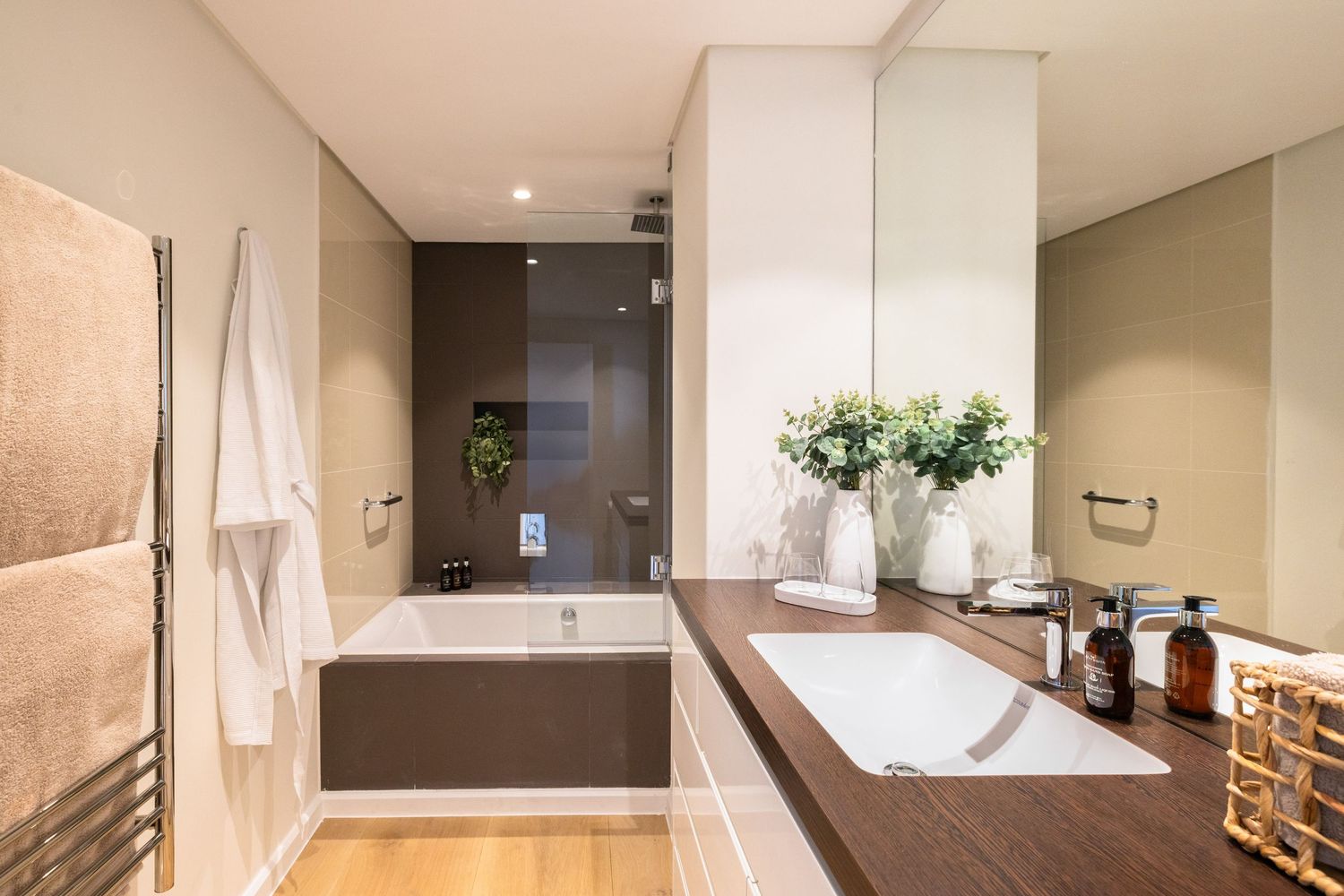 Sleek contemporary bathroom featuring a freestanding white bathtub and natural light from floor-to-ceiling windows.