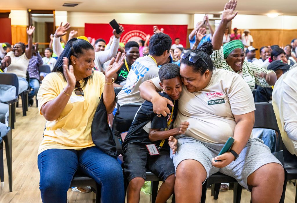 A group of people sitting in chairs while participating in an indoor community gathering or meeting event.