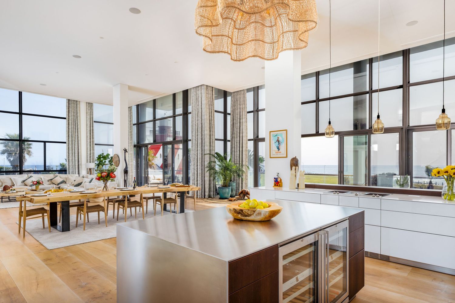 Open concept kitchen and dining area with modern pendant lights and large windows offering natural light.