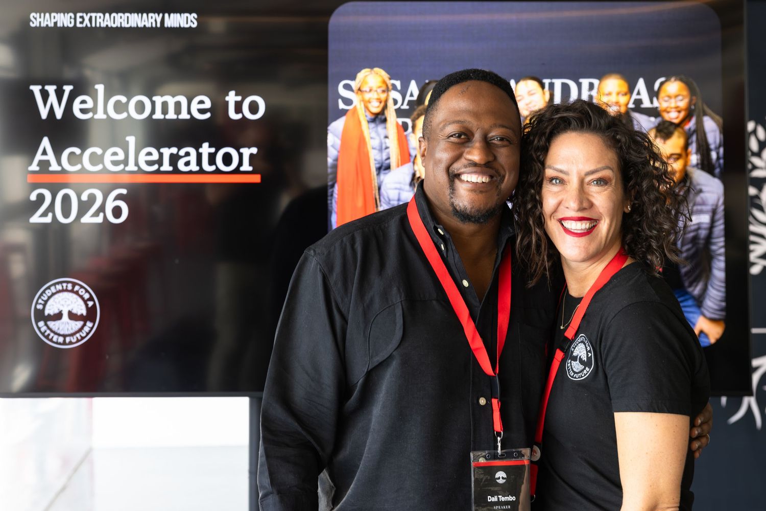 Conference participants gather under welcome signage at a business accelerator event.
