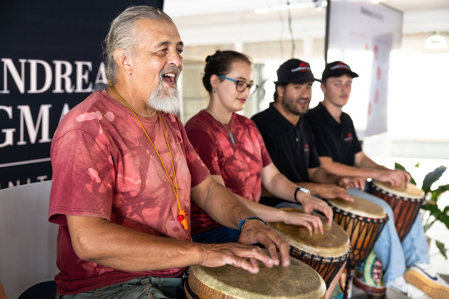 A group of people playing drums together during a musical workshop or performance.