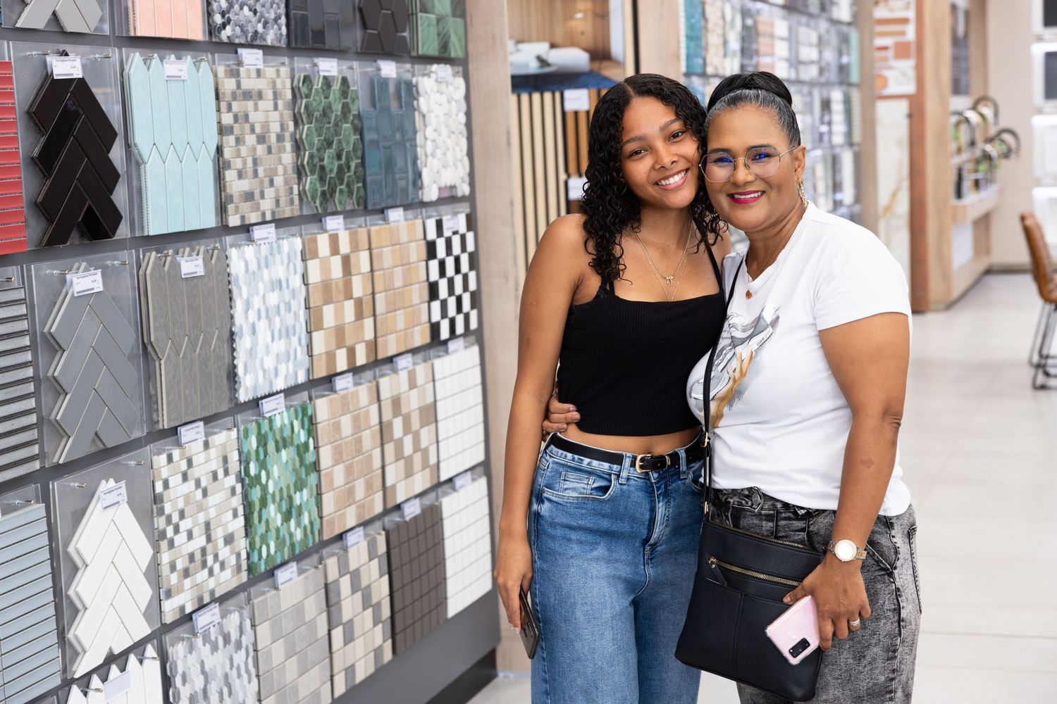 People posing in front of decorative tiled wall in urban setting.
