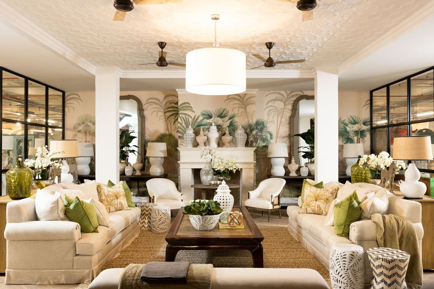 Luxurious white living room with arched columns, pendant lighting, and elegant furniture arrangements.
