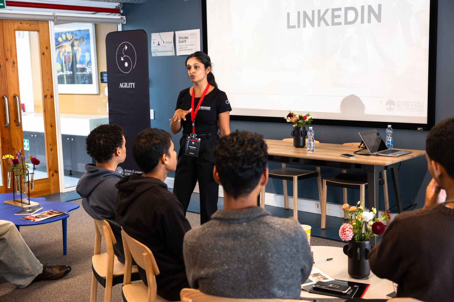Professional speaker presents LinkedIn workshop to engaged audience in conference room setting.