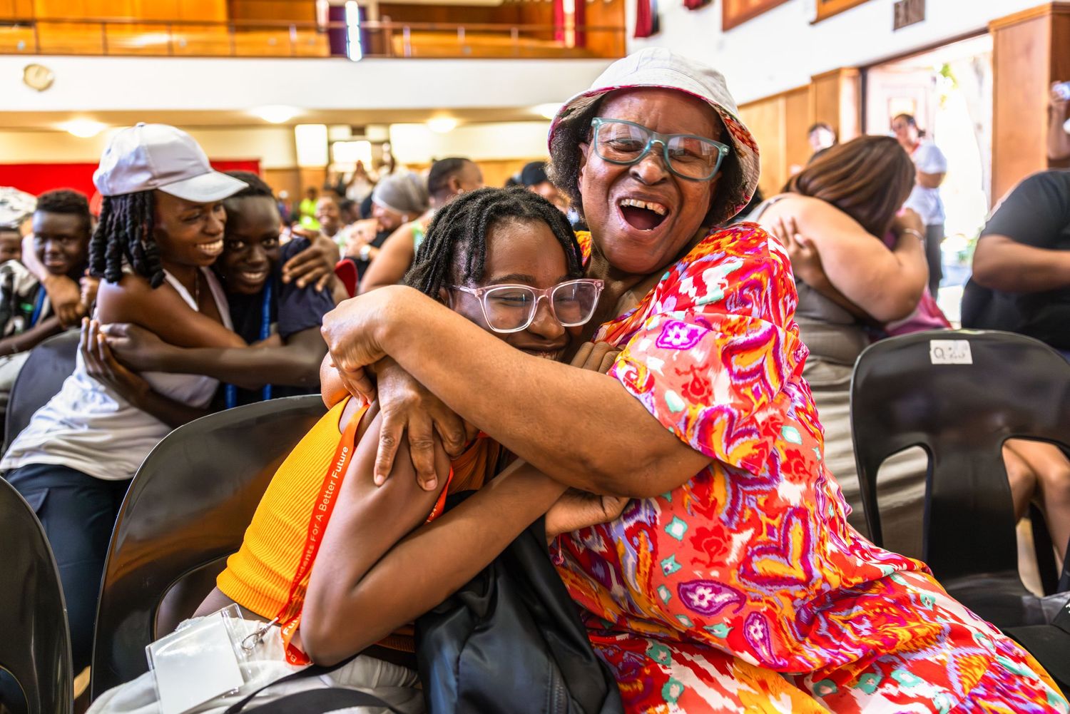 Students sharing excitement and hugging during a celebratory moment.