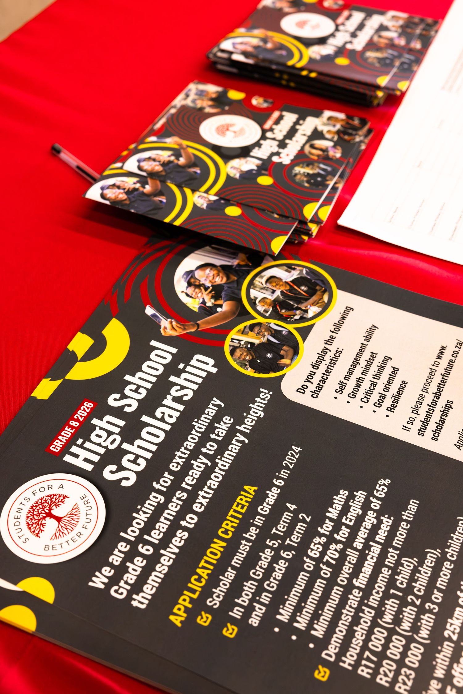 Marketing materials displayed on red background featuring black and yellow design elements.