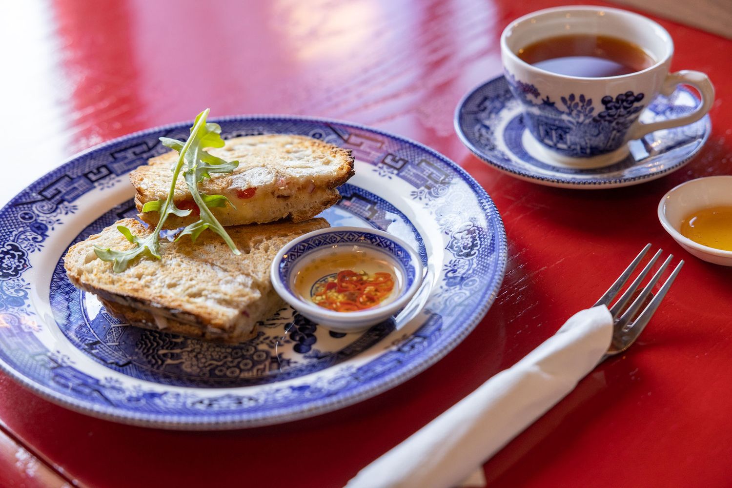 Close-up of sandwich plating on decorative blue and white china with tea service.