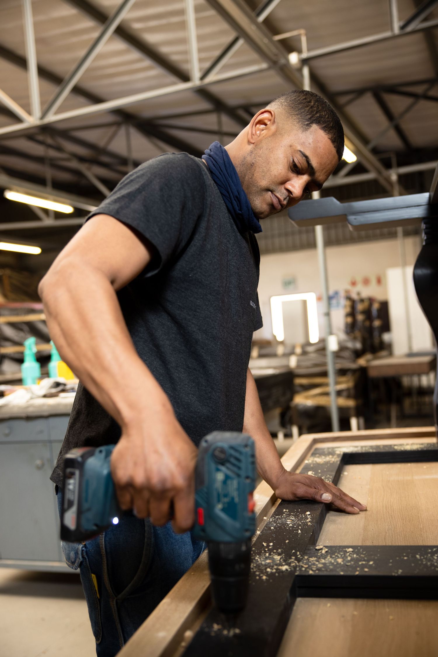 Craftsperson operating industrial equipment in manufacturing workspace.