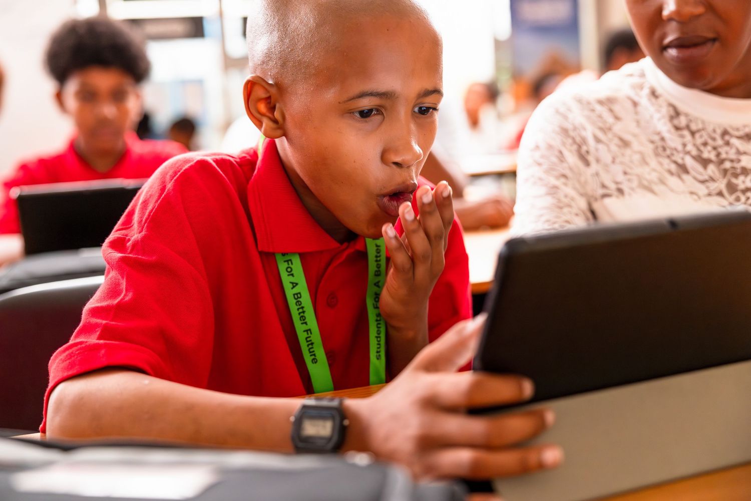 Student engages with content on tablet device during educational session.