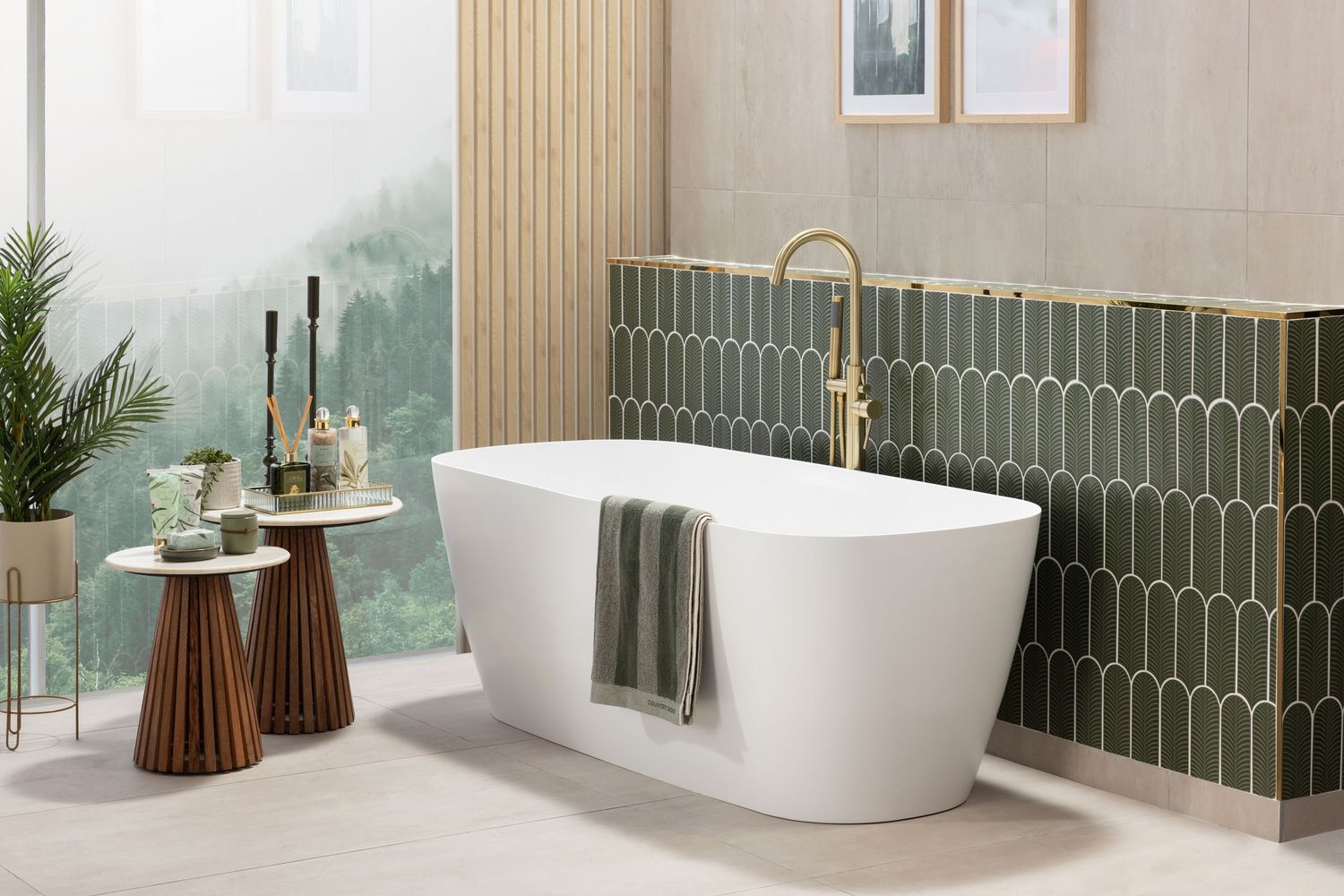 Luxurious bathroom with freestanding tub, brass fixtures, and green geometric tile wall.