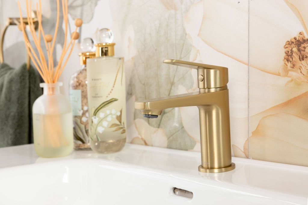 A collection of bathroom accessories including reed diffusers, soap dispensers, and decorative items in neutral tones.