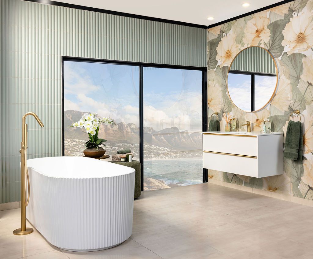 Luxurious bathroom with panoramic windows, ribbed walls, and freestanding tub overlooking a scenic mountain landscape.