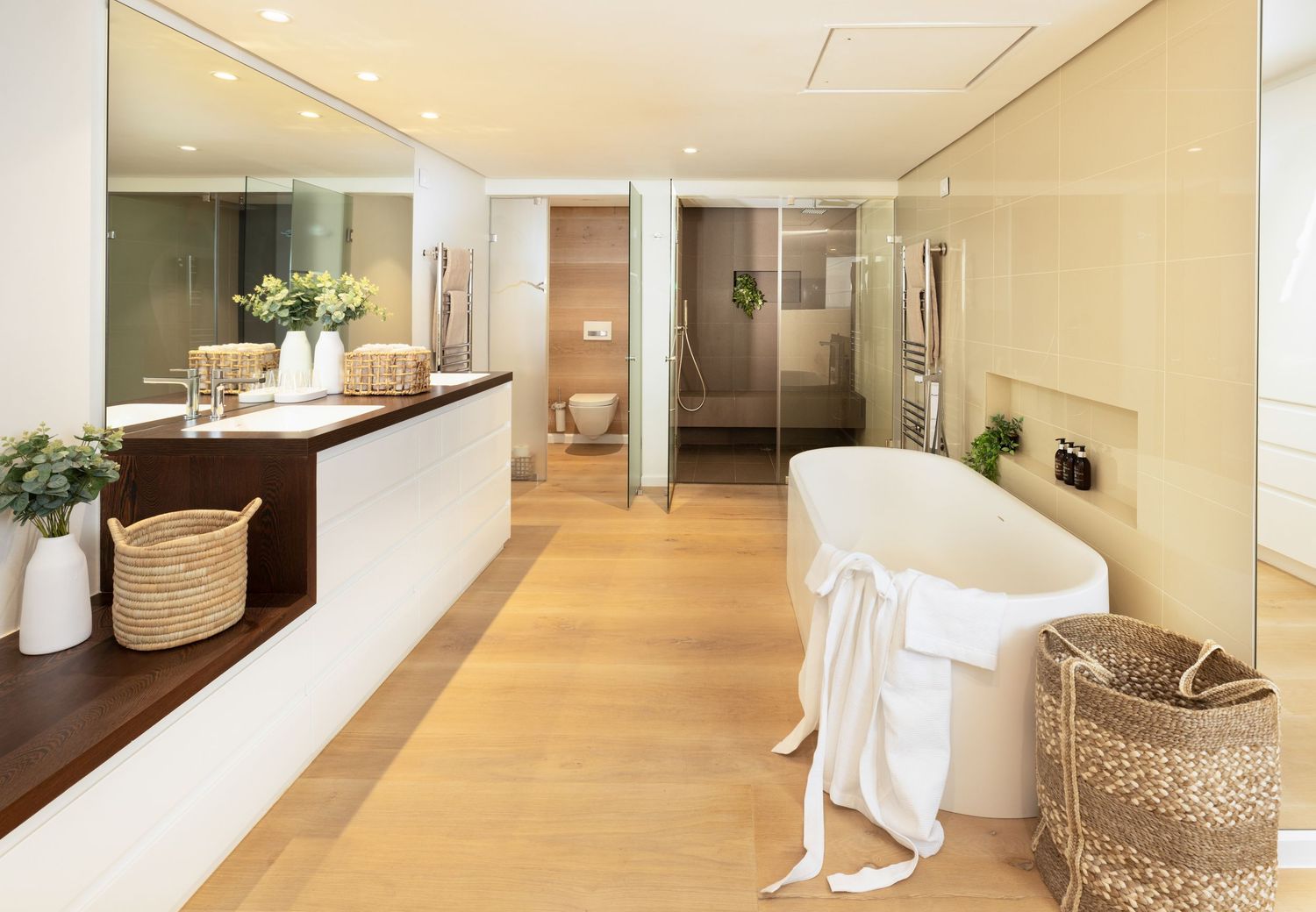 Modern spa-like bathroom interior with beige tones, featuring a freestanding tub and luxurious finishes.