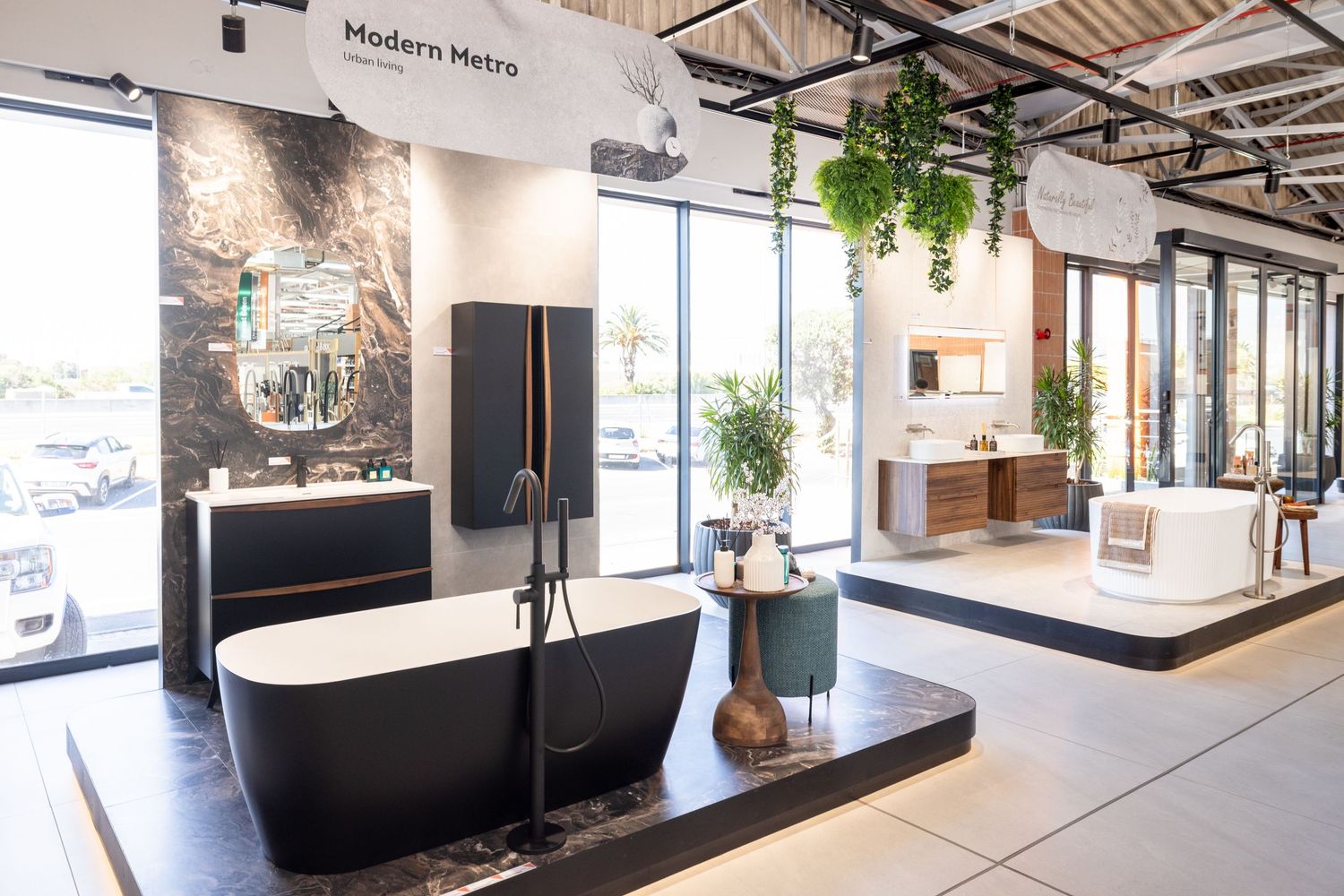 Modern office interior features sleek black and white design elements with natural lighting and hanging plants.
