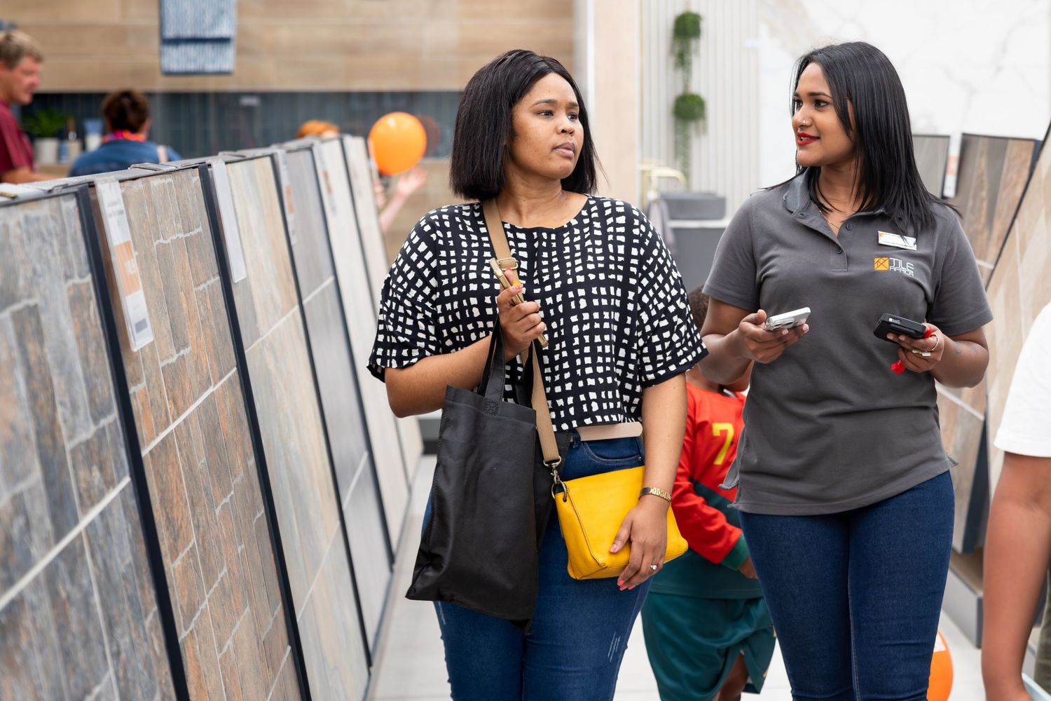 People socializing in a commercial space with orange balloons.