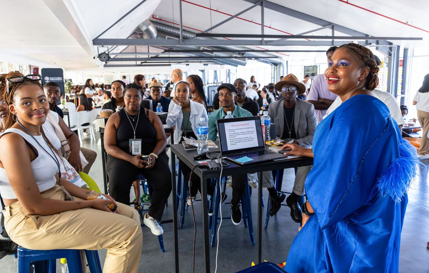 Students gather around laptop displays during an interactive workshop session.