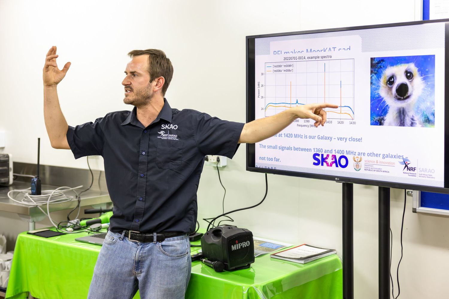 Indoor presentation showing technical diagrams and equipment specifications on display screens.