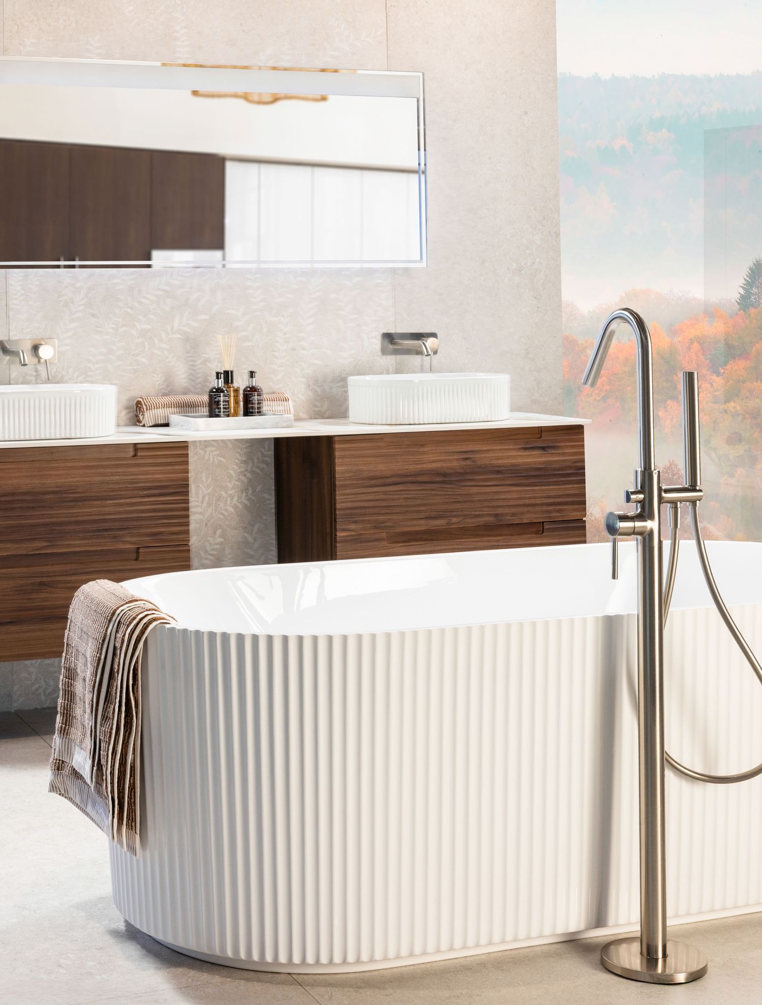 Luxurious bathroom featuring a ribbed white soaking tub, wooden vanity, and contemporary floor-mounted faucet.