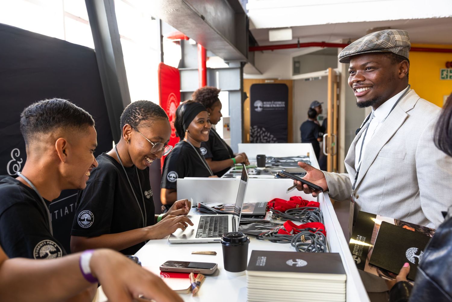 Attendees participate in an interactive learning session at tables with laptops and materials.