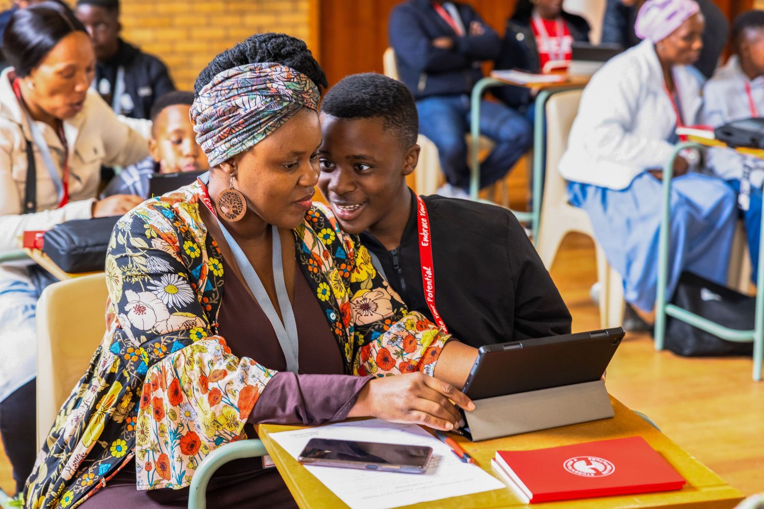 Attendees working together while reviewing content on a digital device.