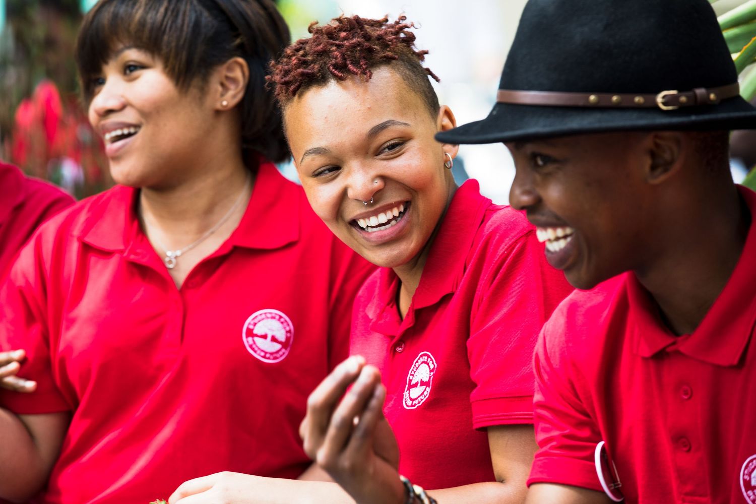Friends in red polo shirts share a lighthearted moment together.