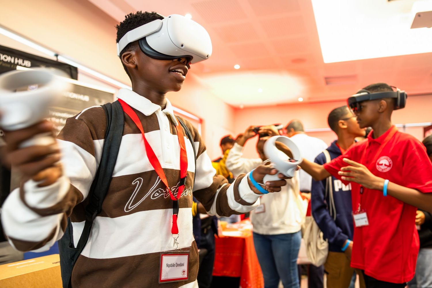 Students participate in hands-on STEM activities while wearing bright red shirts at an educational event.