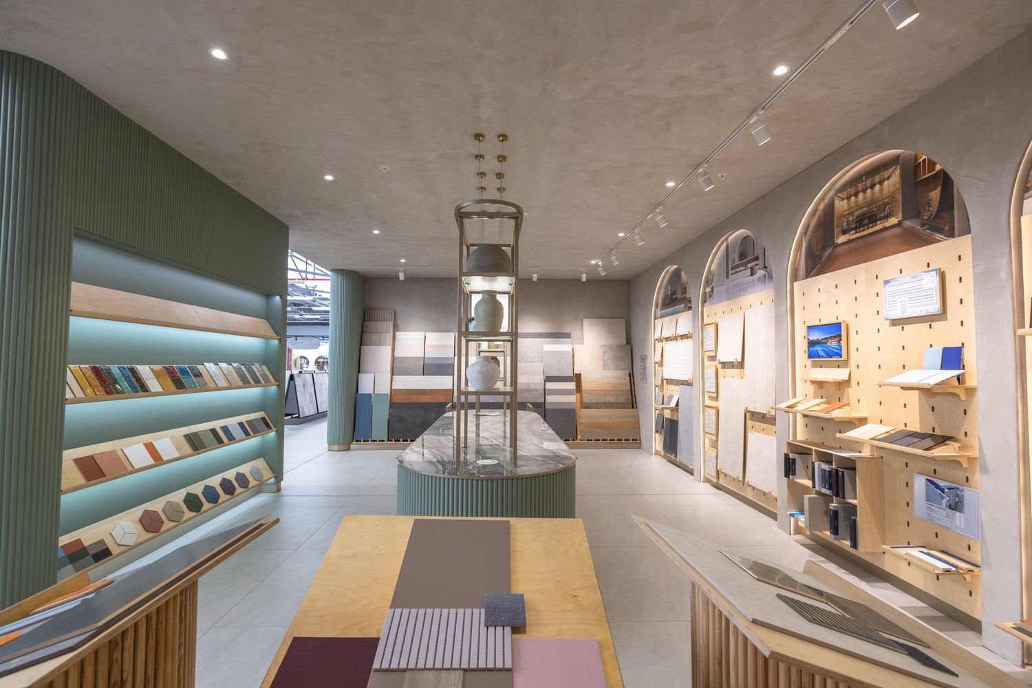 Long gallery corridor with turquoise accents, white walls, and recessed lighting showcasing architectural displays.