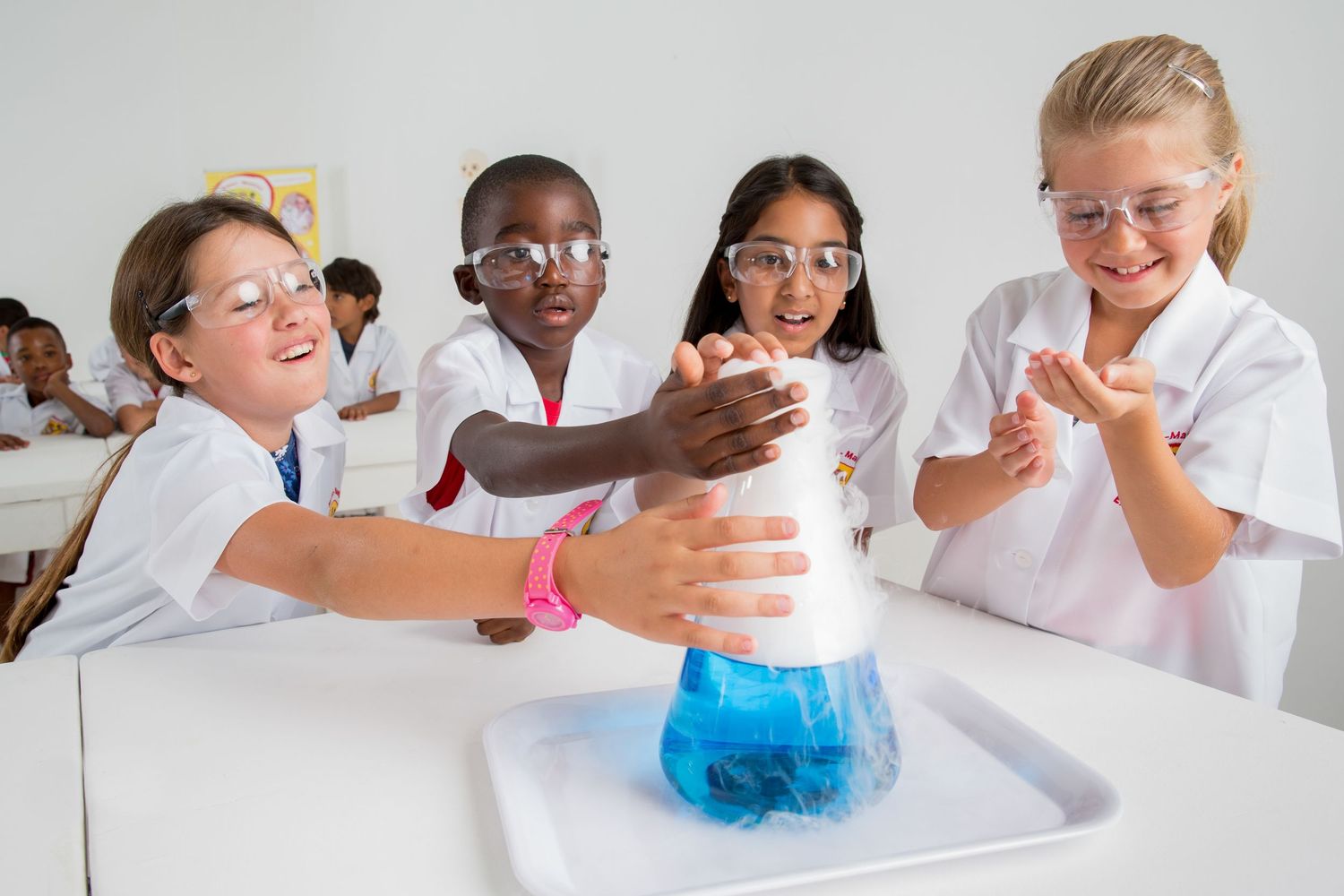 Students in white lab coats react excitedly to bubbling blue liquid in laboratory experiment.