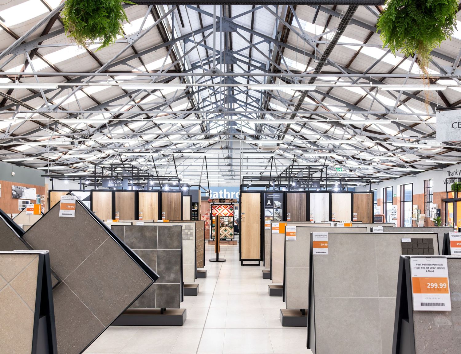 Expansive warehouse showroom with multiple display sections under skylights.