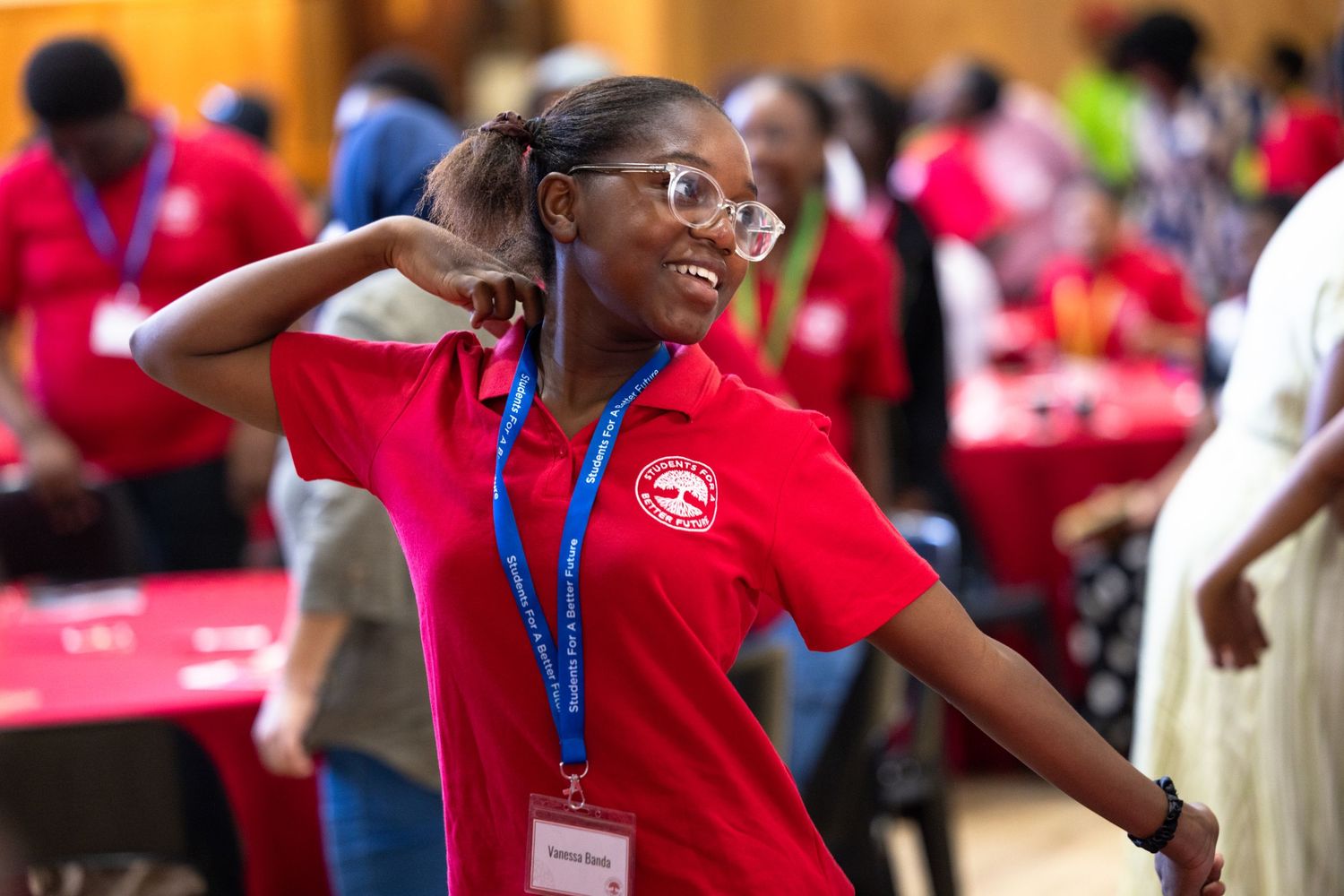 Students wearing red shirts and lanyards participate in an interactive learning session.