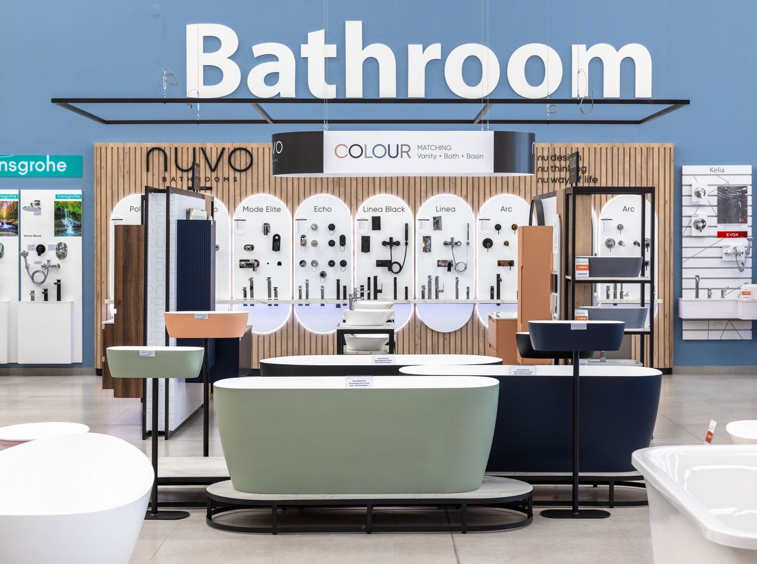 Retail showroom featuring bathroom fixtures and displays under industrial ceiling.
