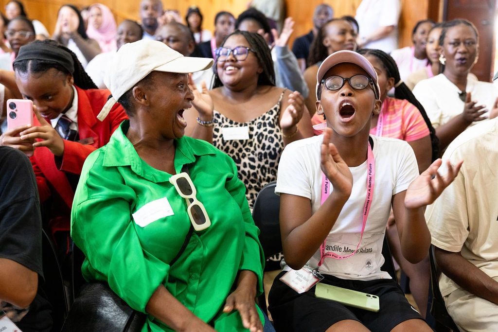 Excited audience members react with enthusiasm and joy during a live performance or event.