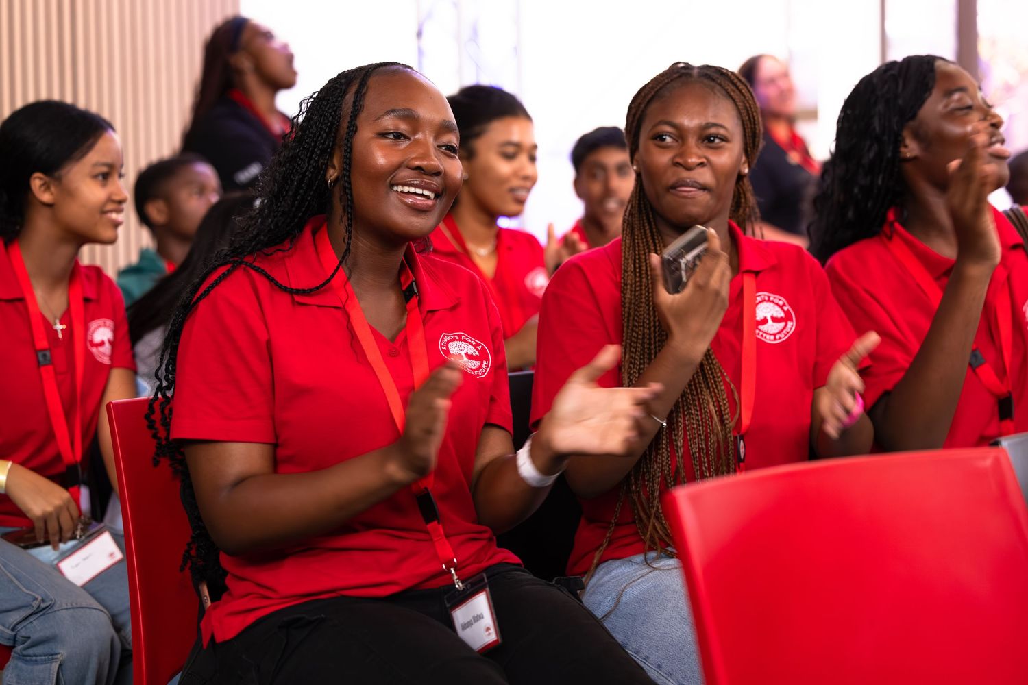 People in matching red shirts show excitement and enthusiasm during what appears to be an event.