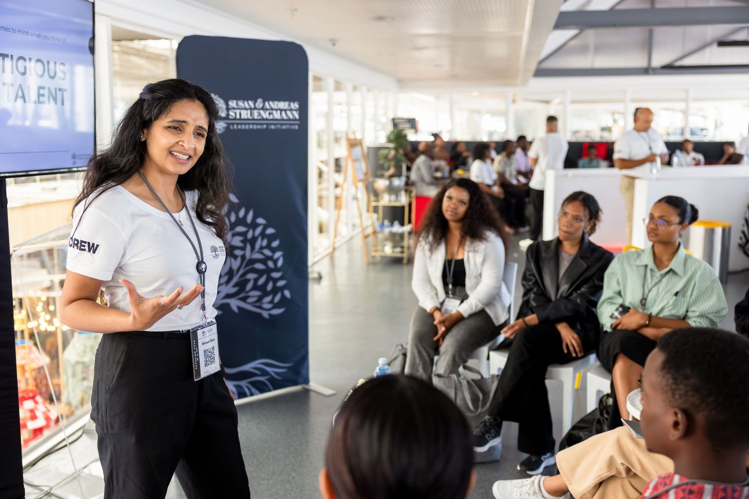 Presenter leading discussion with audience in bright modern office space.