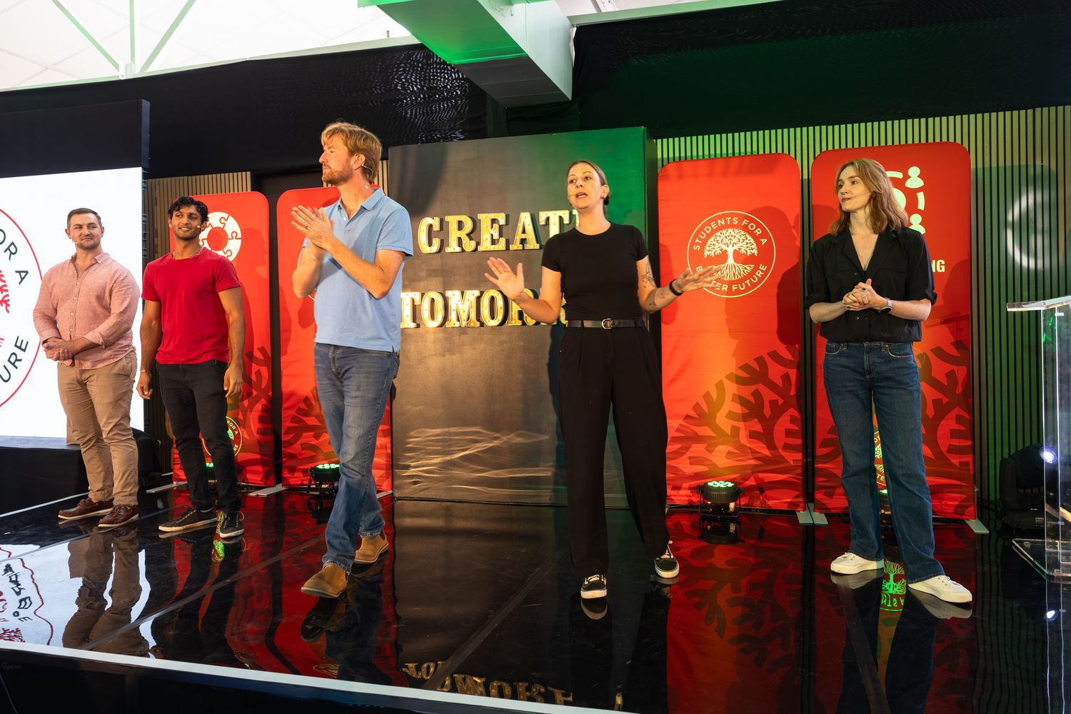 People performing on stage during an improv comedy show with red and green lighting effects.