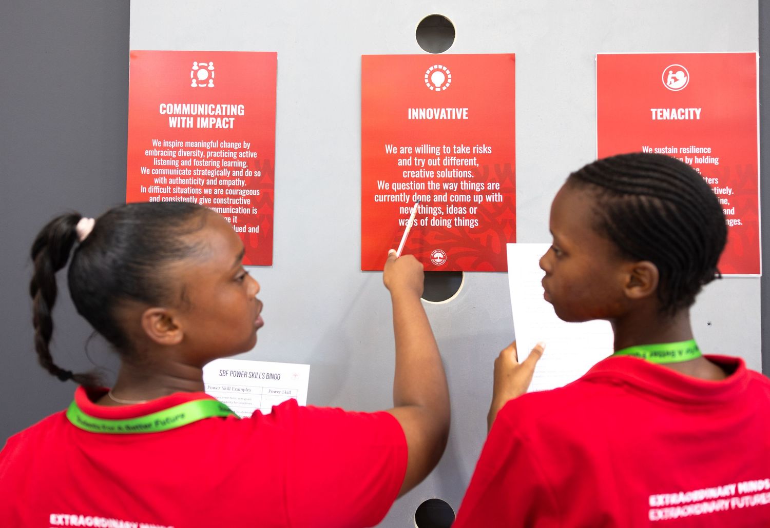 Red informational posters displayed on a wall during an event.