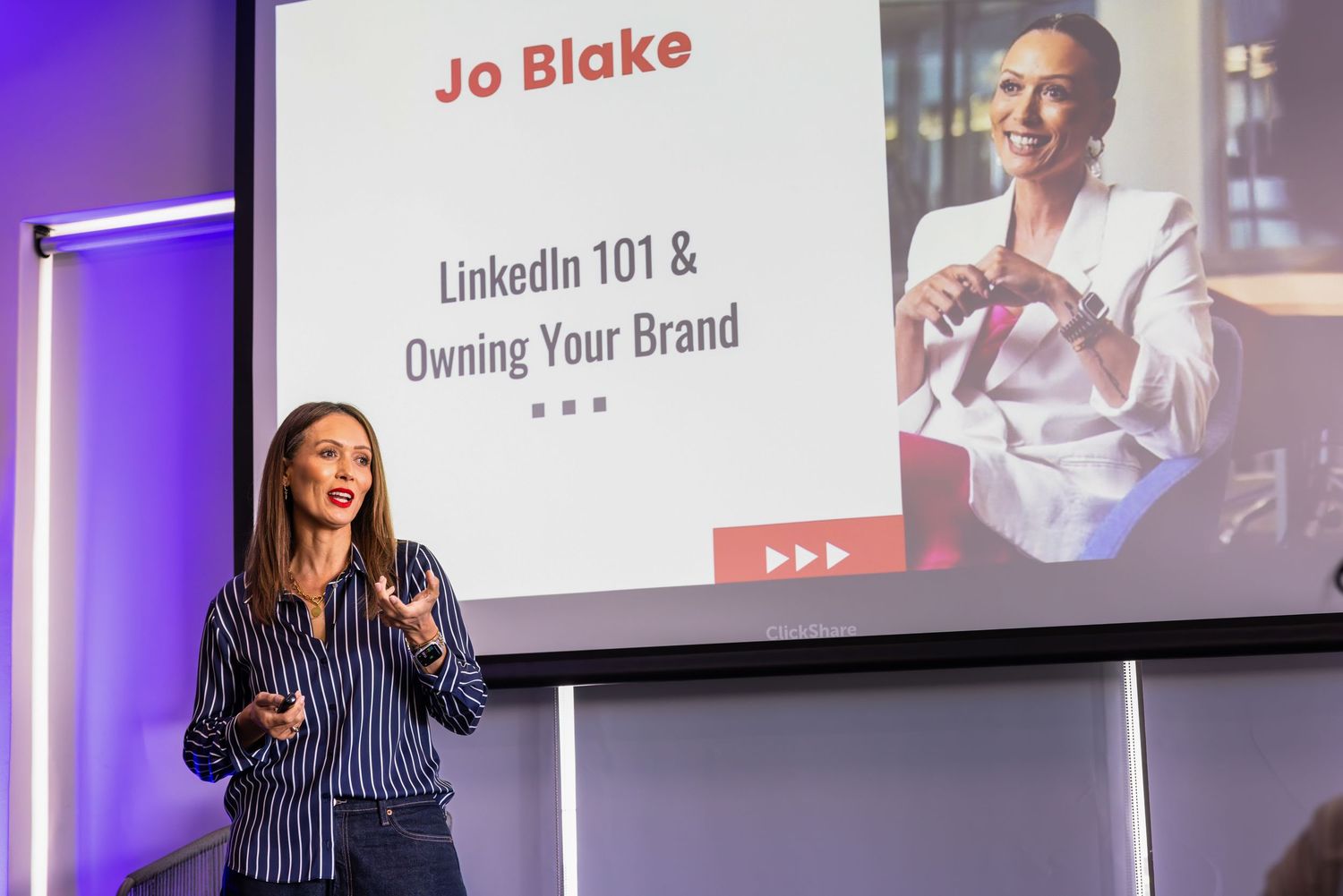 A presentation slide displaying professional branding and speaker information on screen.
