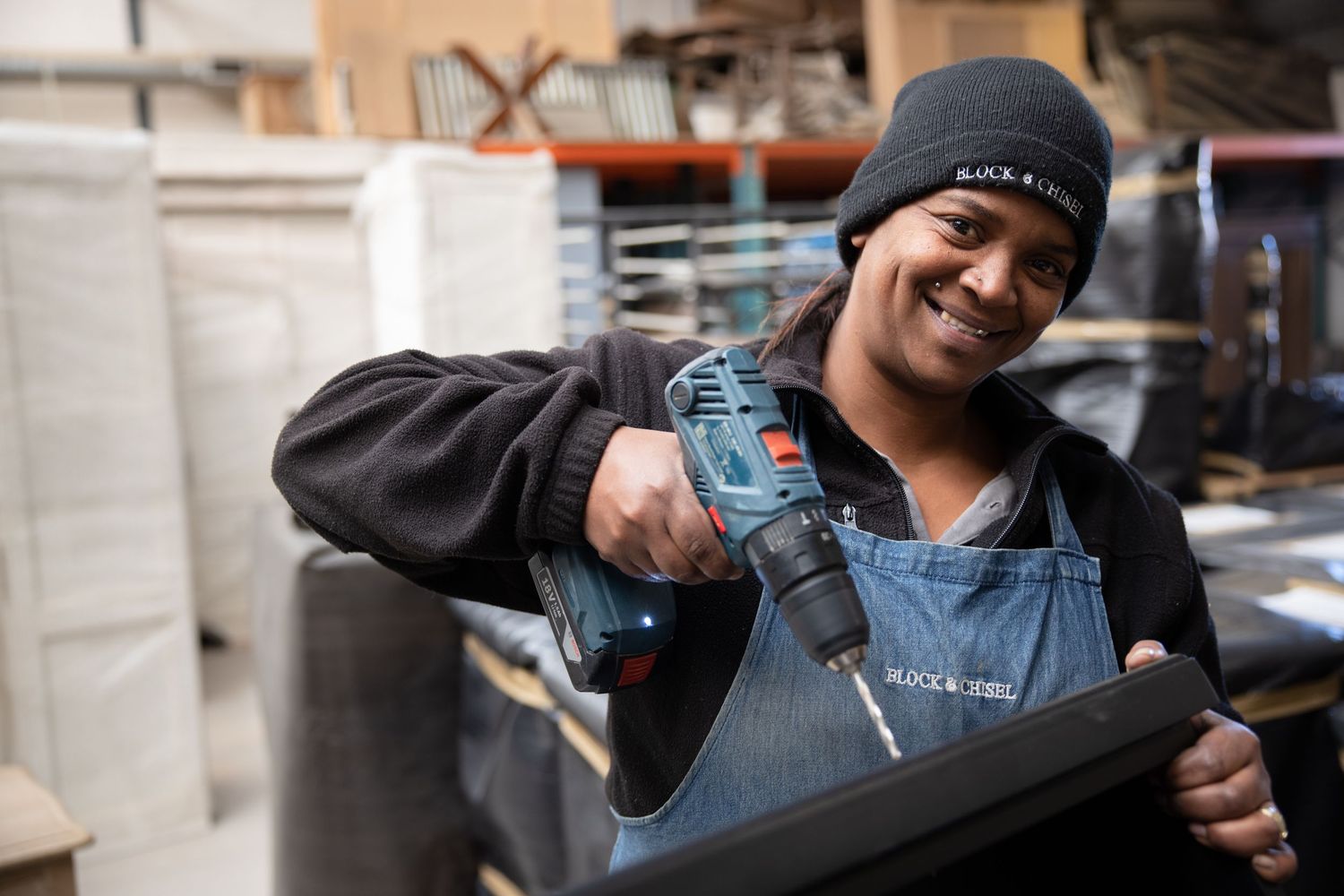 Worker demonstrating use of power tools in manufacturing setting.